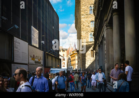 La foule des touristes à l'ombre étroite rue en face de la Galerie des Offices avec le Palazzo Vecchio, Piazza della Signoria et la Cathédrale Dome, à voir Banque D'Images