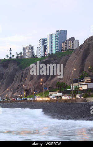 LIMA, PÉROU - le 2 avril 2012 : la côte escarpée et le phare du quartier de Miraflores, comme vu du bord de l'eau dans la soirée du 2 avril, 201 Banque D'Images