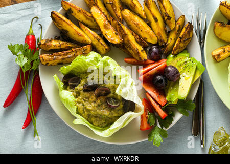 Ensemble de l'usine vegan le déjeuner ou le dîner des pommes de terre au four, baba ganoush, tomate et salade d'. moderne alimentation saine. tourné à partir de ci-dessus. Banque D'Images
