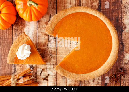 Tarte à la citrouille avec slice retiré. Vue supérieure de la scène de la table sur un fond de bois rustique. Banque D'Images