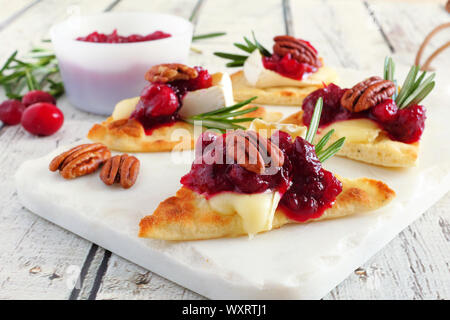 Maison de pain plat hors-d avec des canneberges, pacanes et fromage brie. Close up scène table sur un plateau blanc. Banque D'Images