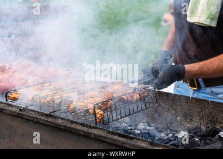 Les faire cuire à la vapeur sur la viande juteuse frites un grill au charbon. L'alimentation et de la cuisine des équipements à un festival de l'alimentation de rue. Banque D'Images