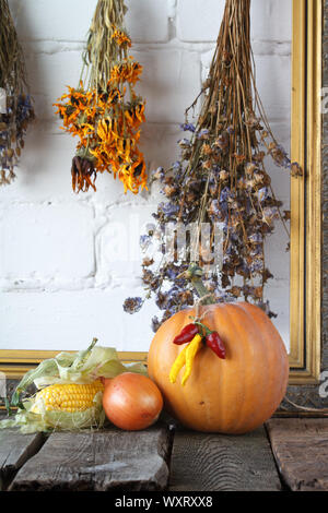 Citrouilles d'automne et d'autres légumes sur la table en bois de grâce, bouquets de fleurs séchées dans un cadre vintage background, selective focus Banque D'Images