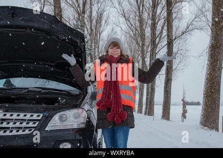Jeune femme a panne de voiture dans l'hiver Banque D'Images