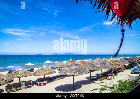 Des parasols de paille sur une plage au Vietnam. Nature paysage tropical. Chaises longues sur la plage de sable. Belle Côte. Banque D'Images