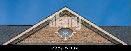 White lucarne évent, gable, corbel, Louvre sur une nouvelle construction américaine de luxe maison unifamiliale dans la côte est USA avec fond de ciel bleu Banque D'Images