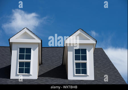 Une lucarne avec un toit bleu ciel nuageux fond sur une nouvelle construction maison aux ETATS UNIS Banque D'Images