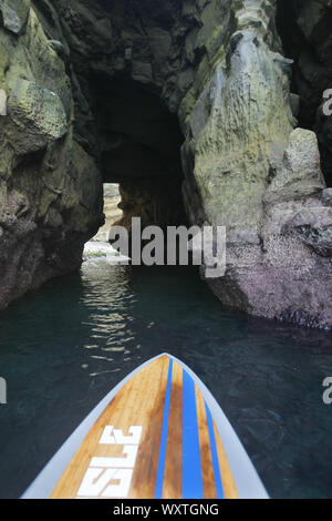 San Diego, Californie, USA. 24 mai, 2010. Un stand up paddle board entre dans une grotte à La Jolla Cove sur une chaude journée d'été. L'anse est protégé en tant que partie d'une réserve marine, qui est riche en vie marine, et est populaire auprès des kayakistes, les plongeurs, nageurs et plongeurs. Credit : KC Alfred/ZUMA/Alamy Fil Live News Banque D'Images