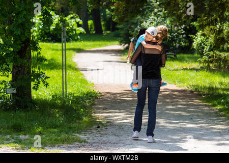 Soeur d'une adolescente portant son frère enfant de petit garçon sur le sentier dans le parc du château d'Esterhazy Palace à Fertod, en Hongrie Banque D'Images