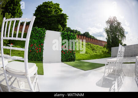 Cadre magnifique pour la cérémonie de mariage en plein air attendent les mariés et les invités. Chaises en bois décorées de fleurs, sont dans la zone de la Banque D'Images