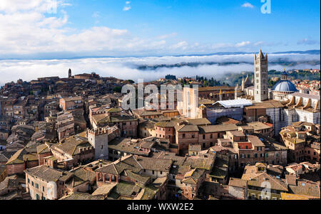 Vue sur les toits de la ville médiévale de Sienne, Toscane, Italie recherche sur le Duomo vers les basses terres nuages dans la distance Banque D'Images