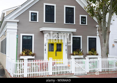 Chalet en bois traditionnel avec porte avant jaune vif et blanc paling clôture à Provincetown, Cape Cod, New England, USA Banque D'Images