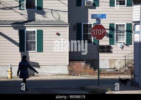 Femme marche passé traditionnel typique des maisons en bois en bois peint dans Thames Street, Newport, Rhode Island, USA Banque D'Images