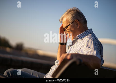 Outdoor portrait of senior man qui a des maux de tête. Banque D'Images