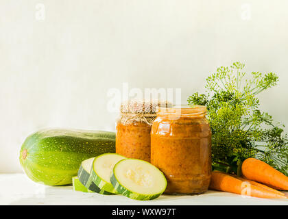 La mise en conserve des légumes fermentés conservés divers courgettes carottes en pots sur une table un fond clair. Traitement de l'automne culture d'été. Fo en conserve Banque D'Images
