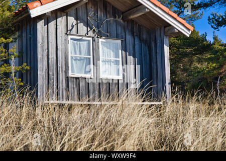 Chalet rustique avec bois d'été attaché et fenêtres avec rideaux net, Sandhamn, archipel de Stockholm, Suède Banque D'Images