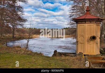 Ancienne station de pompage sur les rives du Isbladskarret congelés, un petit lac sur l'île de Djurgarden, Stockholm, Suède Banque D'Images