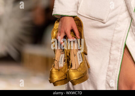 Modèle des femmes portant des chaussures à l'Omi et vin du London Fashion Week SS20 show. Eco friendly vêtements conçus à partir de déchets et de mauvaises herbes Banque D'Images