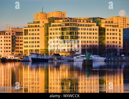 Pleine lune naufrage derrière l'architecture moderne à l'aube, Arsta, Stockholm, Suède, Scandinavie Banque D'Images