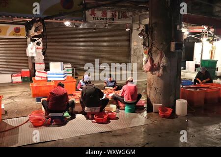 KEELUNG, TAÏWAN - 22 NOVEMBRE 2018 : Les vendeurs de préparer des crevettes au célèbre Kanziding Marché de poisson de Keelung, Taïwan. Banque D'Images