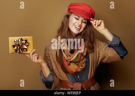 Joyeux 40 ans femme en bonnet rouge, foulard, chemise et veste en jeans carte cadeau doré sur fond de bronze. Banque D'Images