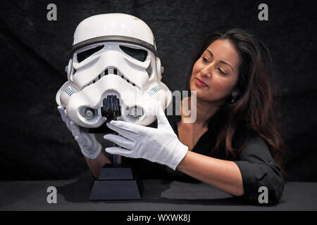 Un employé du magasin Prop est titulaire d'un même écran Tantive IV casque Stormtrooper de Star Wars : Un Nouvel Espoir, lors d'une vente aux enchères aperçu, avant leur vente de souvenirs de divertissement lors de la BFI IMAX à Waterloo, Londres. Banque D'Images