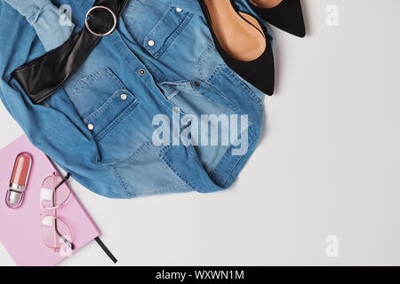 Costume féminin élégant mise à plat. La composition créative avec chemise en jean, chaussures et autres accessoires Banque D'Images