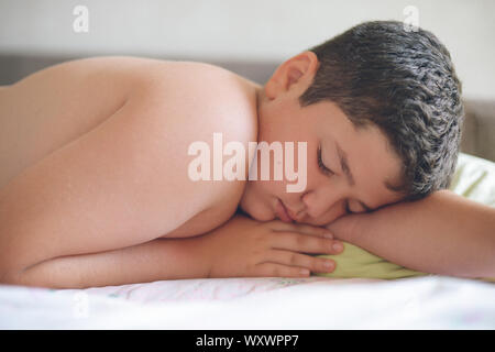 Cute little fat kid caucasienne au lit le matin en sommeil profond oreiller Banque D'Images