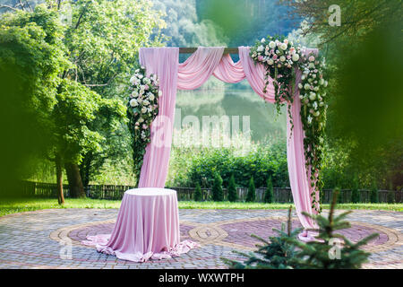 Arche de mariage rose blanc et rose à fleurs à l'extérieur des décorations en vert jardin d'été Banque D'Images
