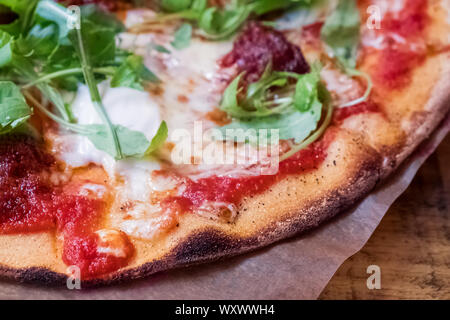 Une délicieuse cuisine italienne pizza à croûte fine et roquette fraîche close-up Banque D'Images
