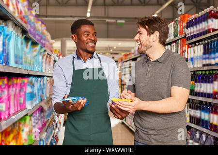 Vendeur africains amis dans le supermarché à une consultation des clients Banque D'Images
