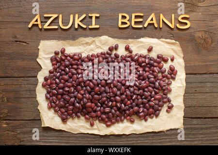 Les haricots azuki brut avec des lettres sur une table en bois Banque D'Images