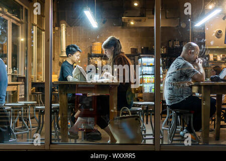 Les clients travailler et profiter de la connexion Wi-Fi gratuite dans un café à Chelsea à New York le Mardi, Septembre 10, 2019. Le wi-fi et les tables communes encouragent l'utilisation de la cafétéria comme un espace de co-working. (© Richard B. Levine) Banque D'Images