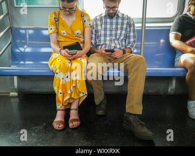 Riders absorbés dans leurs smartphones sur le métro de New York le dimanche, Septembre 1, 2019. (© Richard B. Levine) Banque D'Images