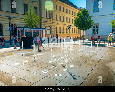 SZEKESFEHERVAR, HONGRIE - le 19 août 2019 : vue sur les enfants et les adultes jouent avec la fontaine d'eau à Szekesfehervar, Hongrie sur une su Banque D'Images