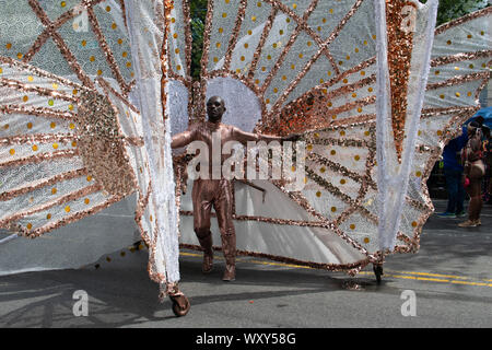 Ein Mann hat sich ein Kostüm erstellt, das wie ein Schmetterling anmutet. Rollen präsentiert auf der Mann stolz sein und geht im Kunstwerk ZickZack un Banque D'Images