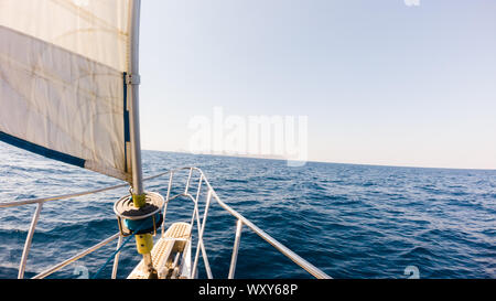 Un voyage à Égine avec un grand yacht de luxe allant vers l'île au milieu d'un océan d'un bleu profond au cours d'une journée chaude en fin de semaine. Banque D'Images