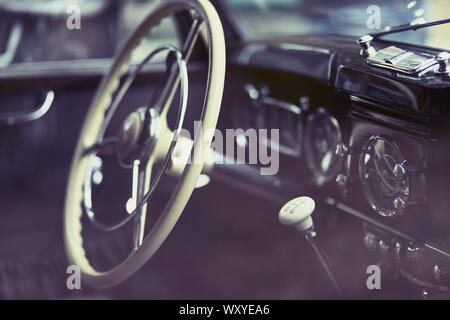 Close-up du cockpit d'une voiture d'époque montrant le volant et pignon Banque D'Images