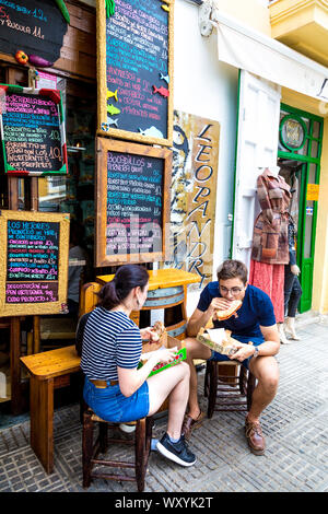 Deux personnes de manger des sandwichs à l'extérieur ,petit restaurant gastronomique dans Sa Marina offrant bocadillos avec jambon ibérique, Ibiza, Espagne Banque D'Images
