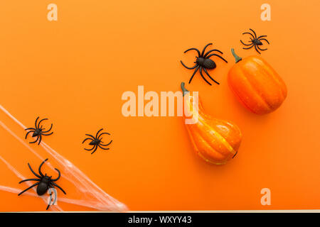 Fond d'Halloween avec des citrouilles, Spider web et des araignées comme symboles d'Halloween sur fond orange. Happy Halloween concept. Cadre. Banque D'Images