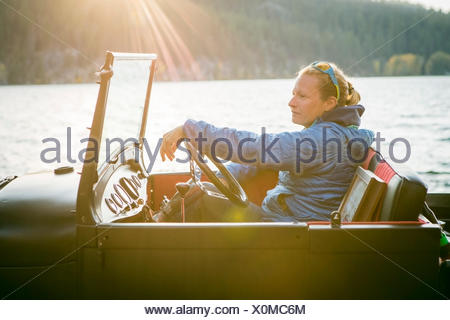 Jeune femme assise Vue de côté en camion rénové en regardant le coucher du soleil, New York, USA