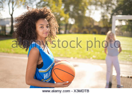 Portrait of young woman holding basketball