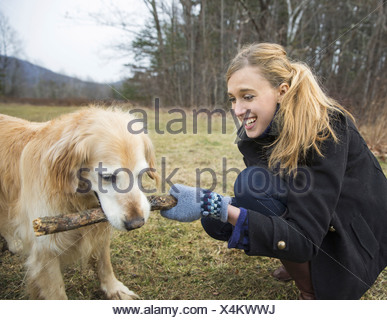Une jeune femme à l'extérieur l'hiver sur une marche avec un golden retriever dog