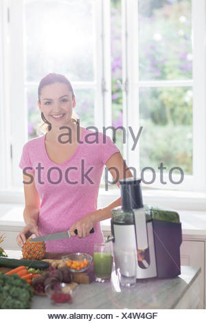 Portrait smiling woman slicing ananas en jus