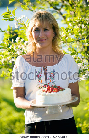 Femme avec un gâteau aux fraises, Fejan, archipel de Stockholm, Suède.