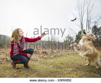 Une jeune femme à l'extérieur l'hiver sur une marche avec un golden retriever dog