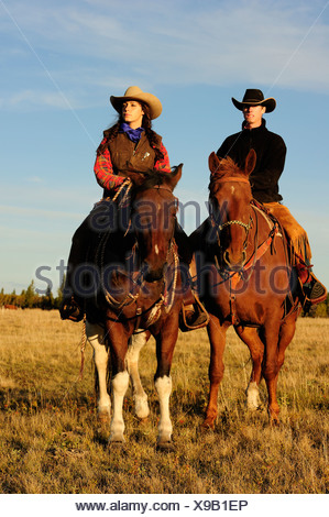 Cowboy et cowgirl monter à cheval, à la recherche dans la distance, de la Saskatchewan, au Canada, en Amérique du Nord Banque D'Images