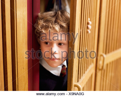 Boy (4-7) en se cachant dans le casier, close-up