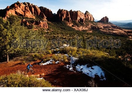 Un homme d'âge moyen chevauche son vtt à travers la roche rouge, près de Sedona, AZ.