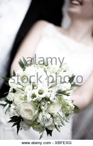 Close-up midsection of a bride holding a bouquet